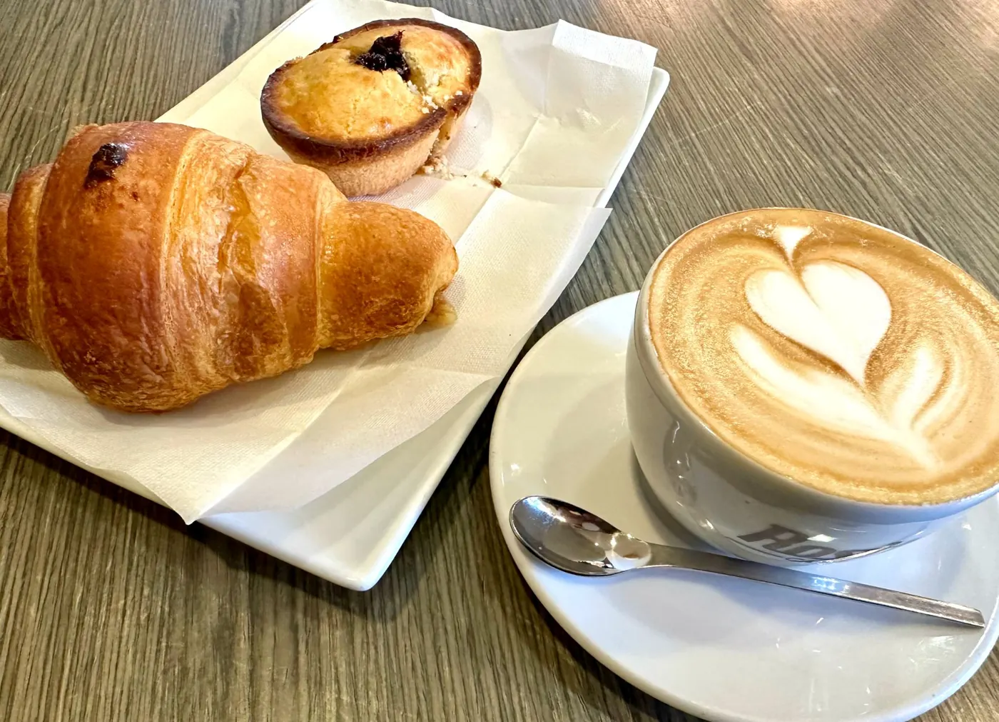 Cornetto, brioche e cappuccino con latte art a forma di cuore